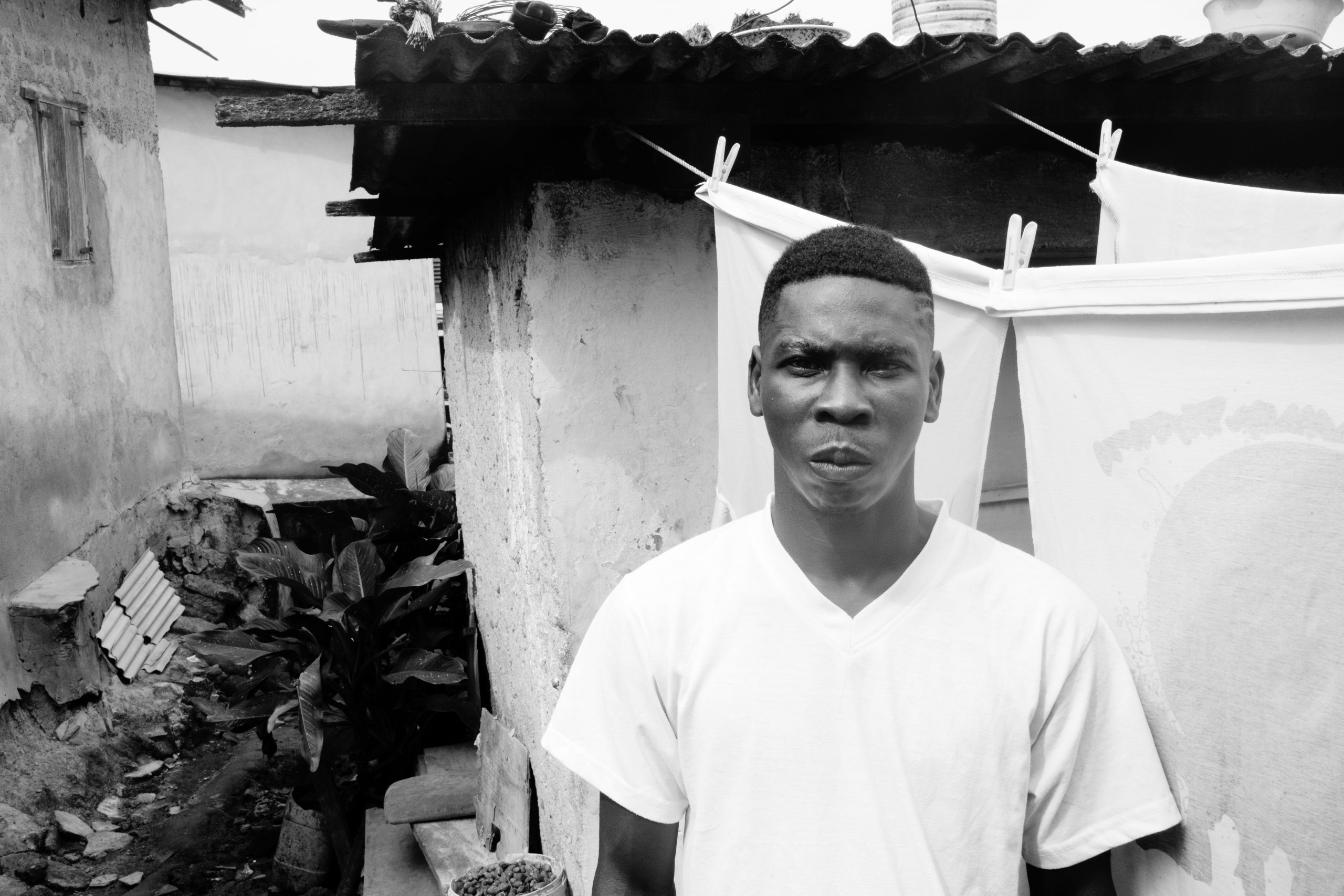 Afrikansk mand foran skur